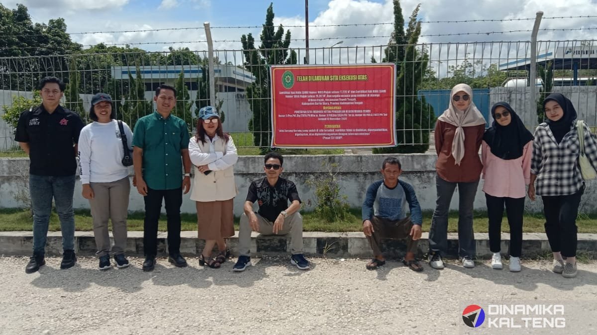 Perwakilan penggugat, kuasa hukum, dan tim lainnya berfoto bersama di depan lokasi lahan SPBE yang telah dipasang tanda sita eksekusi oleh Pengadilan Negeri Muara Teweh (foto: DINAMIKA KALTENG/mas)