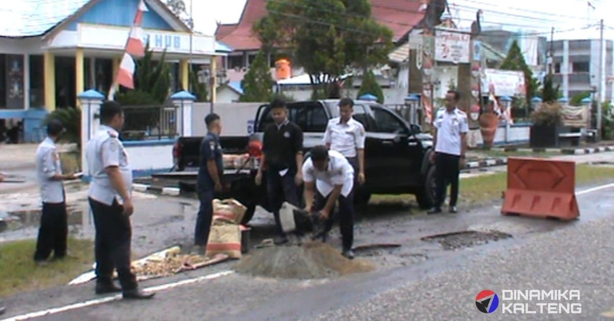 Sejumlah petugas dari Dinas Perhubungan Barito Selatan sedang bersiap menutup jalan berlubang di kawasan perkantoran menggunakan material sementara, seperti semen dan batu, untuk mencegah kecelakaan. (foto: DINAMIKA KALTENG/mas)