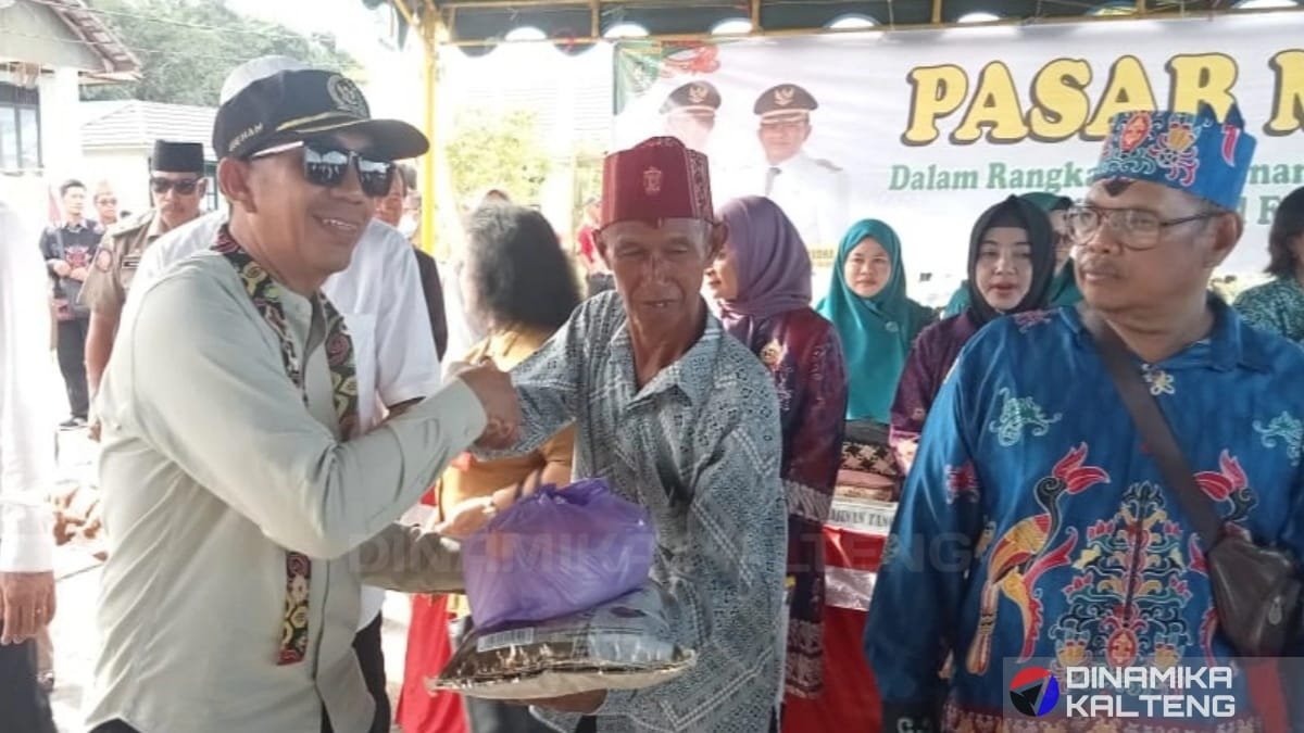 Wakil Ketua I DPRD Barito Selatan, Ideham, menyerahkan paket sembako kepada warga dalam pembukaan pasar murah di Kecamatan Dusun Hilir. (foto: Dinamika Kalteng/mas)