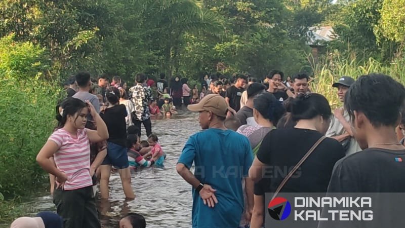 Ratusan warga bermain air di jalan tergenang banjir di Buntok, Barito Selatan