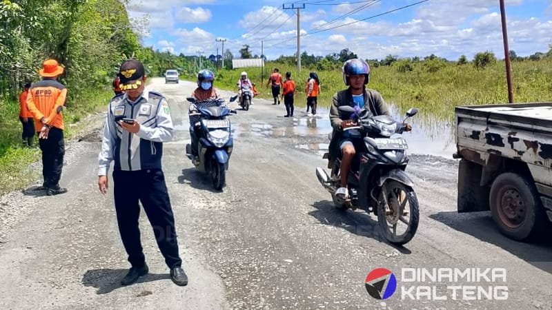 Petugas Dishub dan BPBD Barsel mengatur lalu lintas di jalan tergenang banjir di jalur Trans Kalimantan