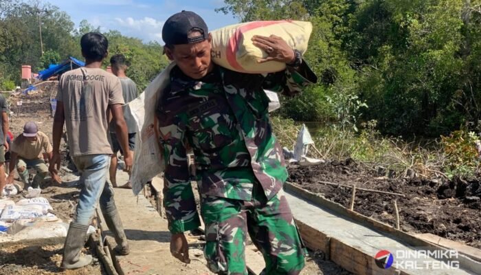 Prajurit TMMD Kodim 1012/Buntok Pikul Semen Demi Pembangunan Jalan di Desa Talio